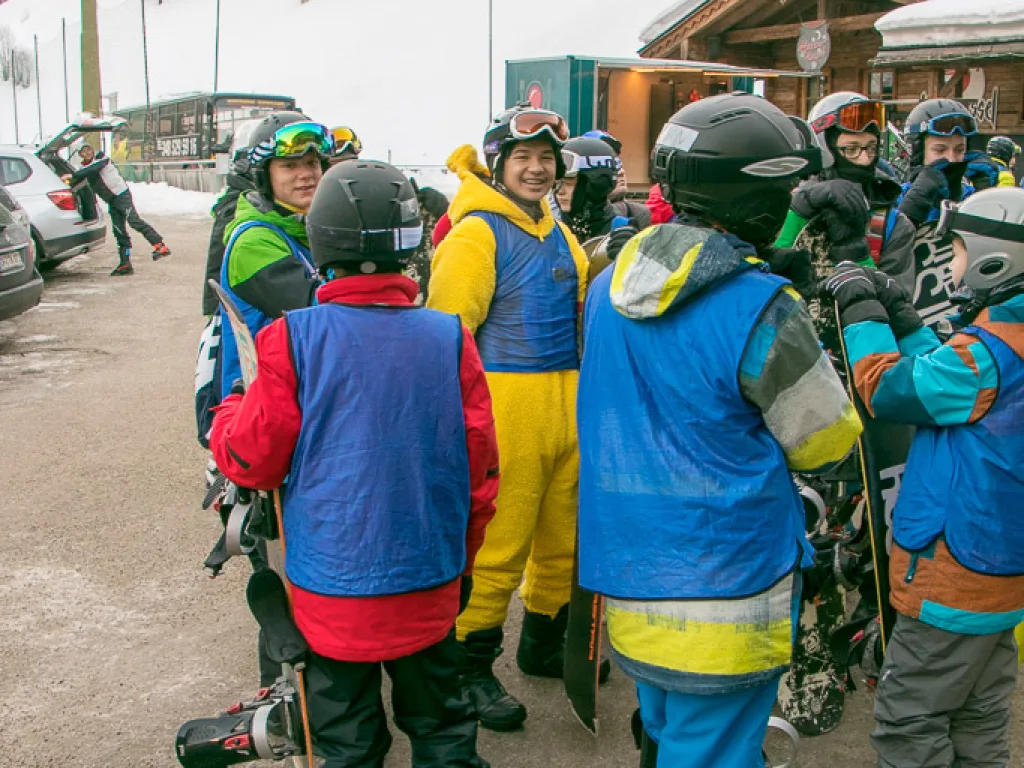 Jugendliche mit Snowboards stehen beisammen.
